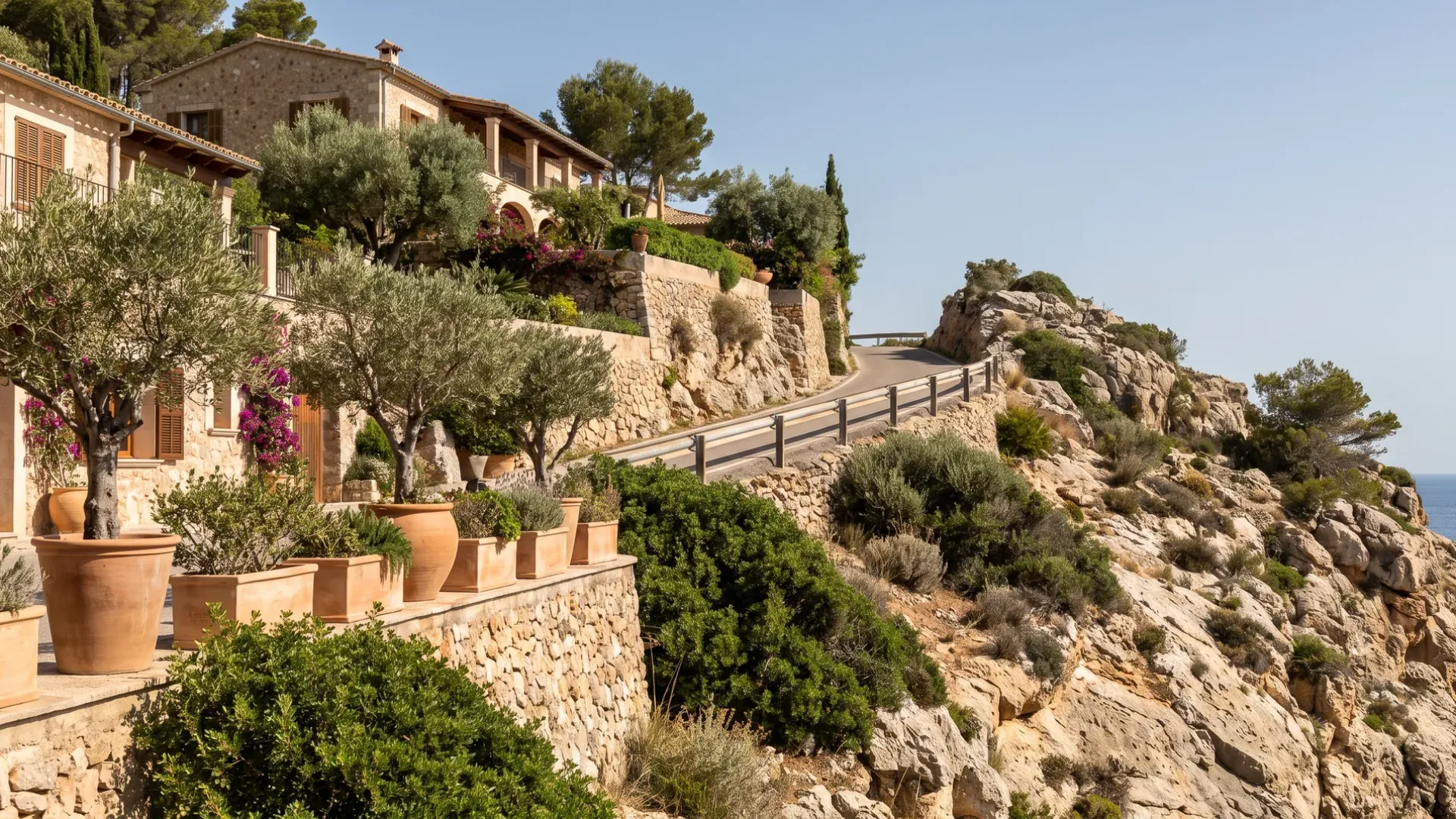 Terraced villa plots cut into the rock above the harbour at Port d'Andratx, planted in built beds and containers